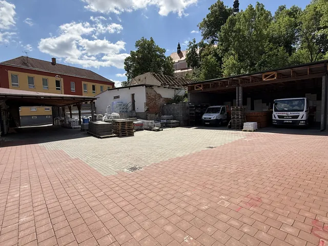 Dvůr s přístřešky a firemními vozy