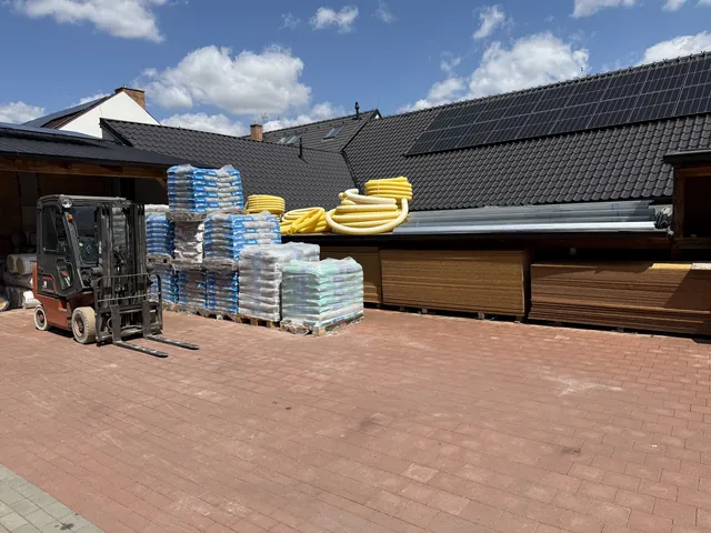 Dvůr s vysokozdvižným vozíkem a paletami materiálu