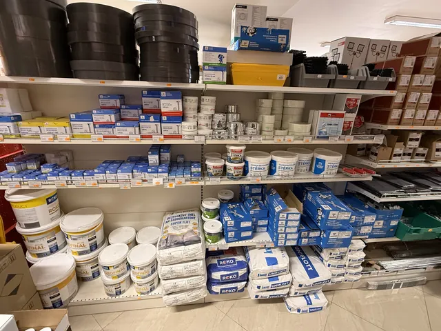 Lepidla, stěrky a sádrové směsi v regálu prodejny