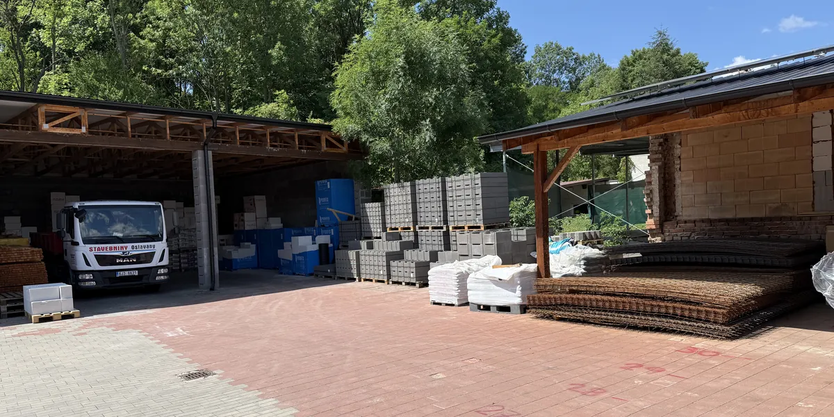 Dvůr areálu Stavebnin Oslavany s krytými sklady a nákladním autem