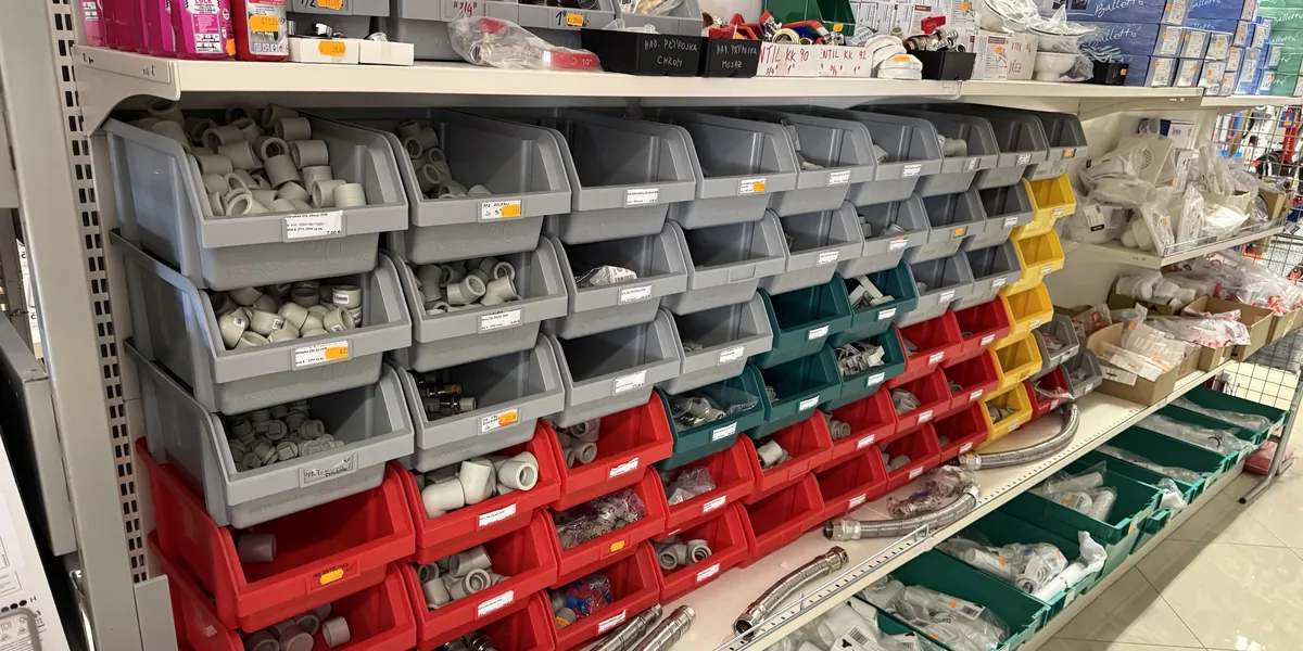 Přihrádky s instalatérskými tvarovkami a drobným materiálem v prodejně Stavebniny Oslavany